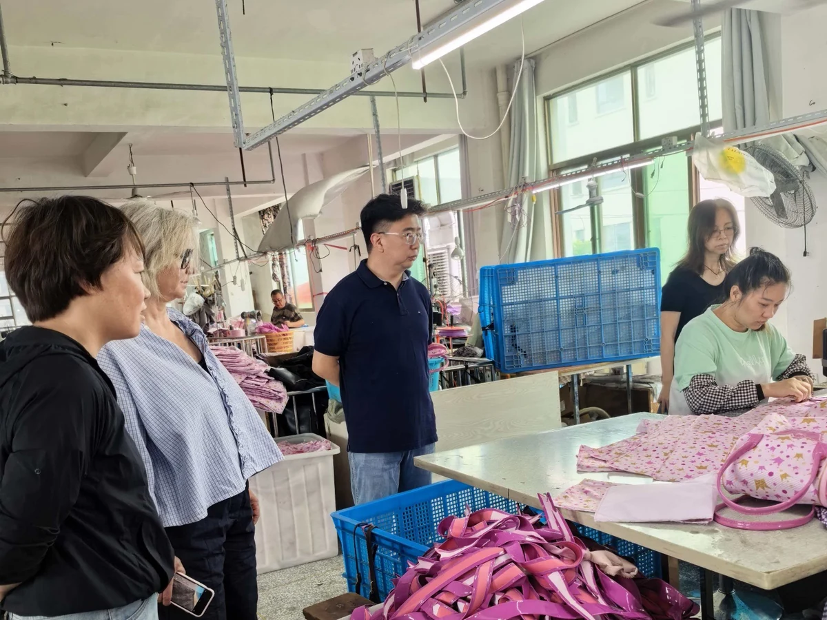 Compradores de marcas avaliam a produção de bolsas.